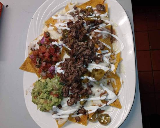 Loaded steak nachos with guacamole, salsa and crema
